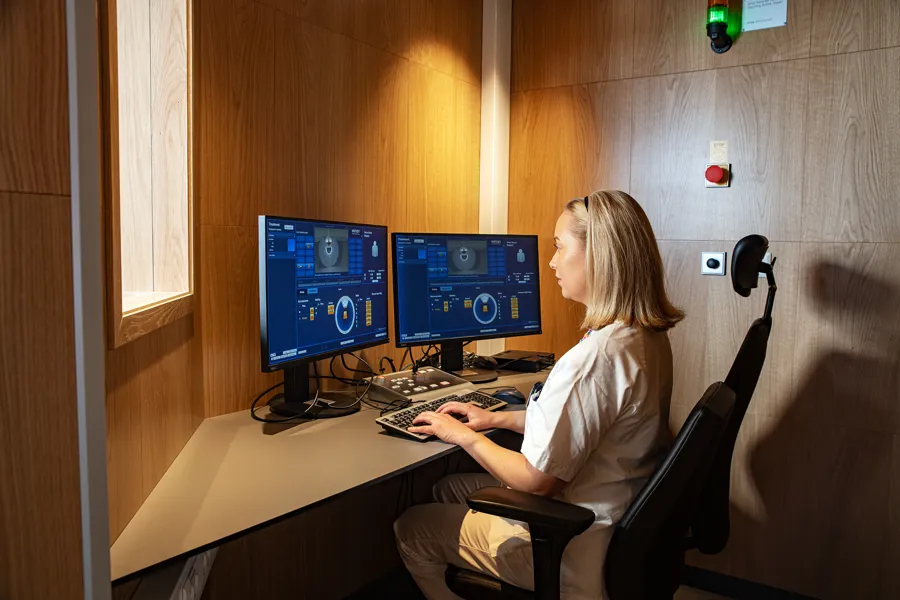 En person som sitter ved et skrivebord med en datamaskin